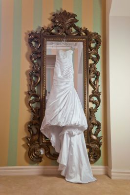 wedding dress hanging in front of mirror