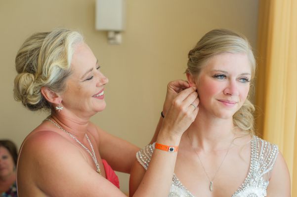 brides mother helping the bride with her jewelry