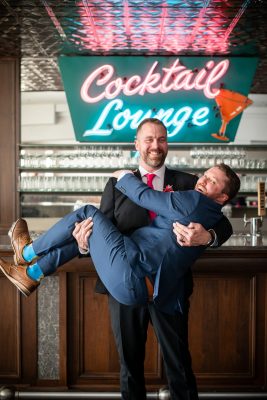 Groom having fun holding a groomsmen