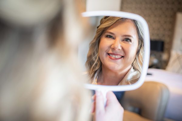 Bride looking at her reflection in the mirror in Chatham